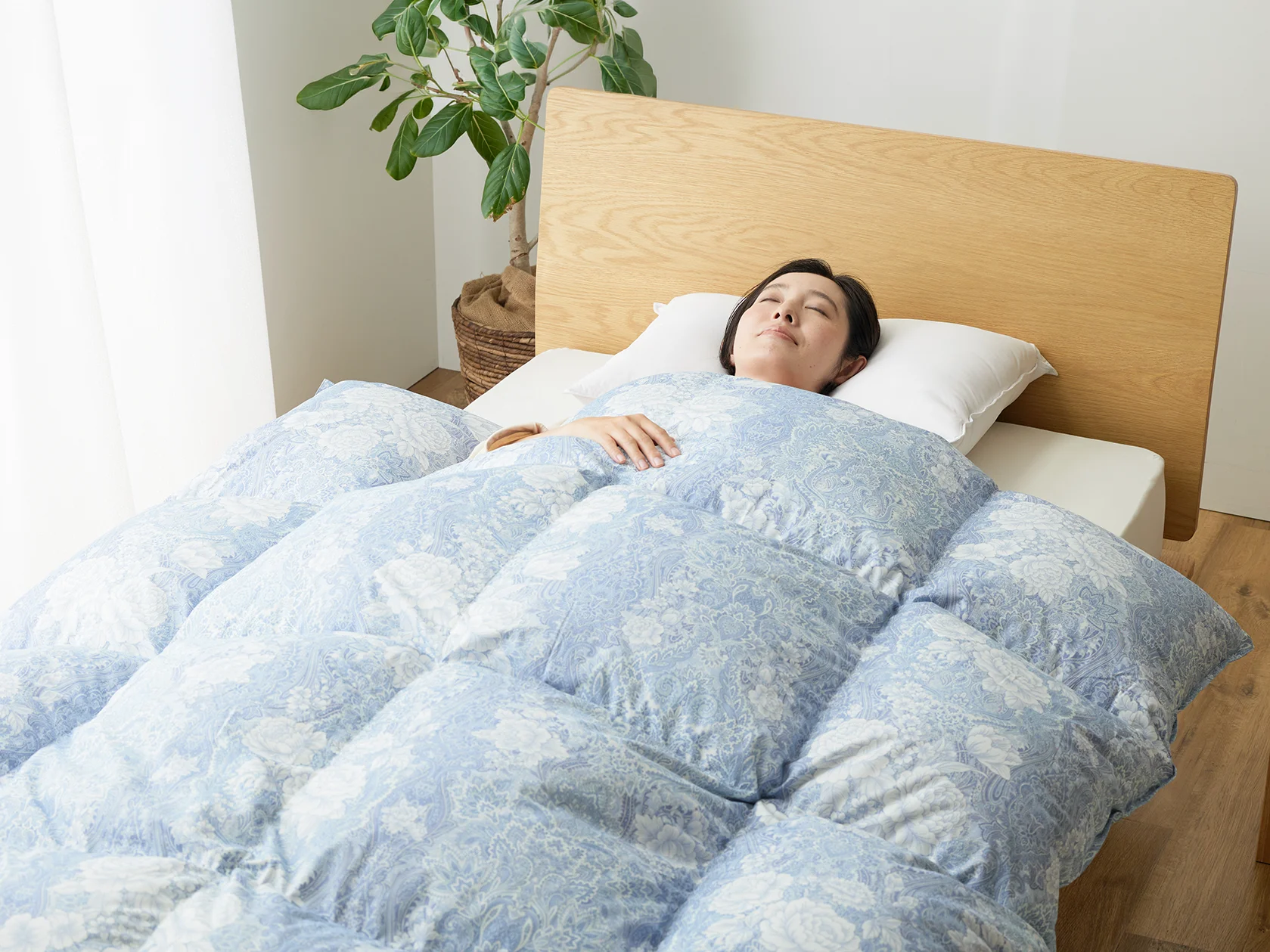 洗える軽量生地の羽毛ふとんを使用する様子